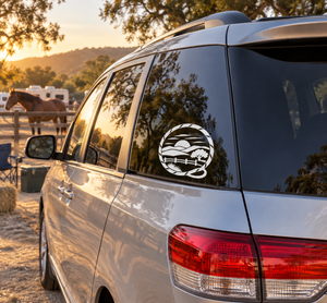 Vinyl decal with circular ranch landscape crest on car door window.