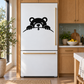 Refrigerator vinyl decal of a black bear peeking over a line