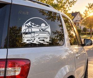 White adventure vehicle vinyl decal with mountains, trees, and moon on a car window