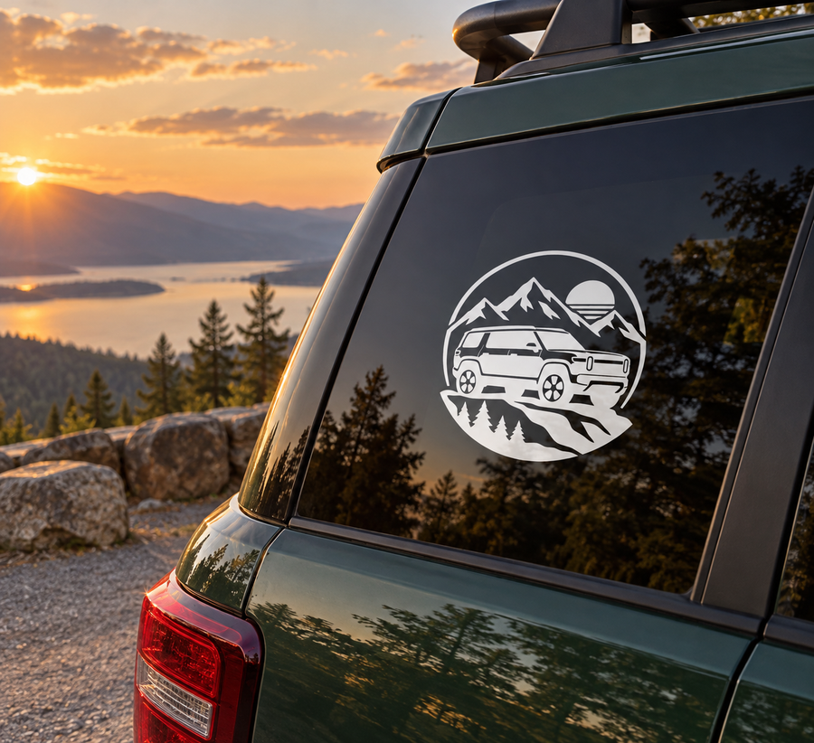 Vinyl car decal on rear window: circular mountain and off-road vehicle graphic in white.