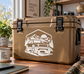 Rivian R2 adventure vinyl decal with mountain-and-truck outline on tan cooler