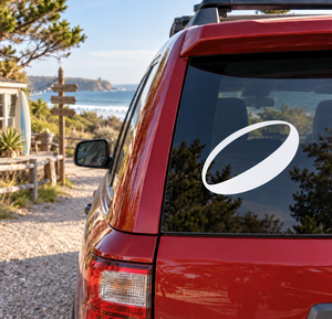 Vinyl rugby oval ball decal on rear window of red car, white oval with black outline