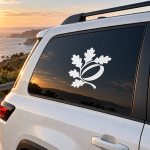 Vinyl decal of oak leaf emblem with acorn, white design on dark surface