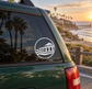 Circular vinyl decal with white pier-and-waves icon on a car window