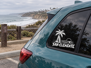 Teal car window with black palm and San Clemente longboard wordmark vinyl decal