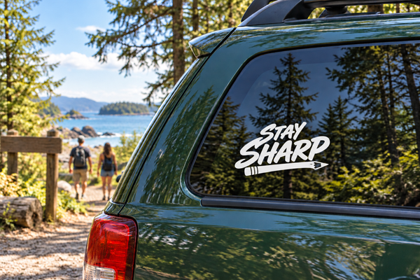 White “Stay Sharp” vinyl decal on dark car window glass