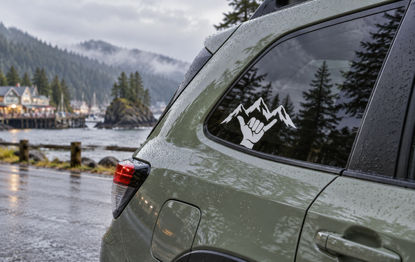 Mountain shaka vinyl decal with black hand and mountain outline on a vehicle window