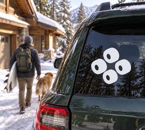 Quartet skateboarding vinyl decal on car window, four black wheel shapes with white centers
