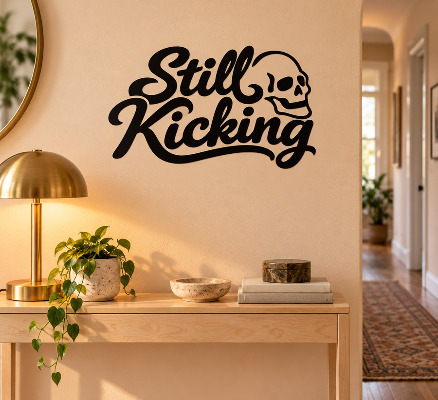 Still Kicking vinyl decal with black script and skull icon