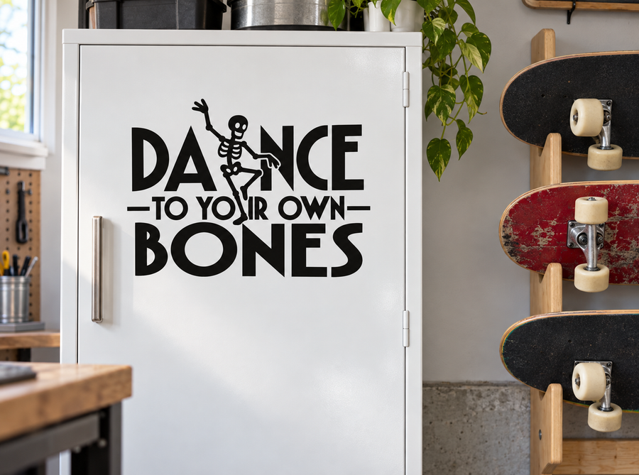 Vinyl decal with black text “DANCE TO YOUR OWN BONES” and skeleton dancer graphic