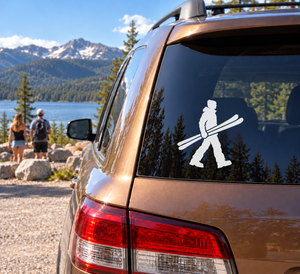 Skiing vinyl decal of a person walking with skis on a car window