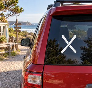 Crossed skis vinyl decal on car rear window, white skis on dark glass