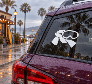 Ski goggles vinyl decal in white and black on dark car glass.