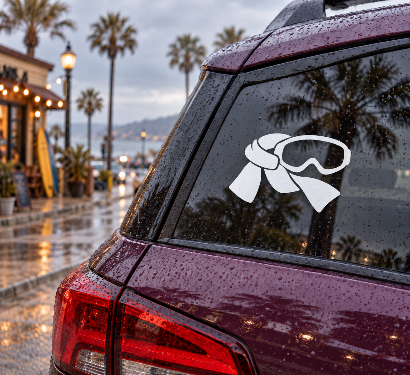 Ski goggles vinyl decal in white and black on dark car glass.
