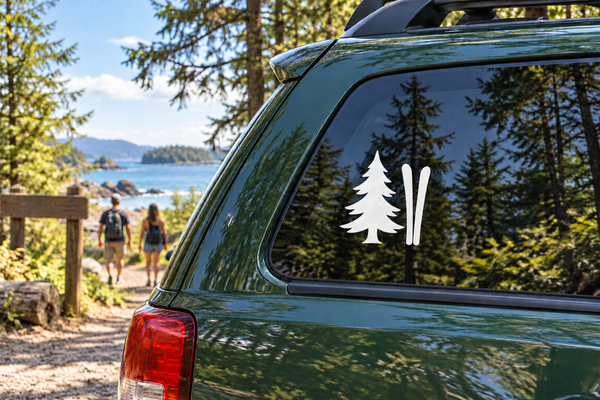 Vinyl decal of a pine tree and two skis on a car side window