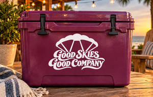 White parachute and "Good Skies Good Company" vinyl decal on purple suitcase