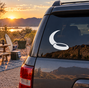 Vinyl decal with black crescent moon and white swirl on dark window