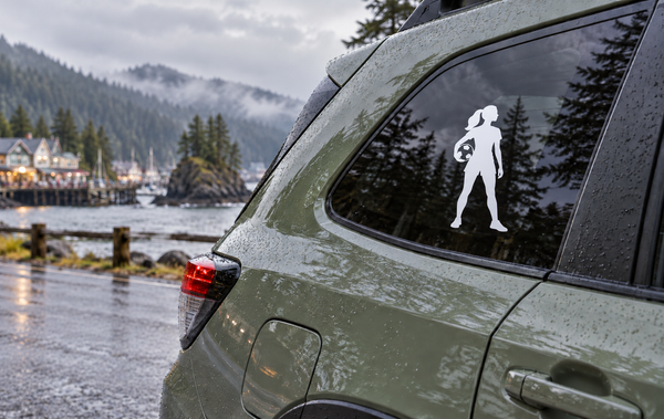 White vinyl soccer player decal holding a soccer ball on a car window.