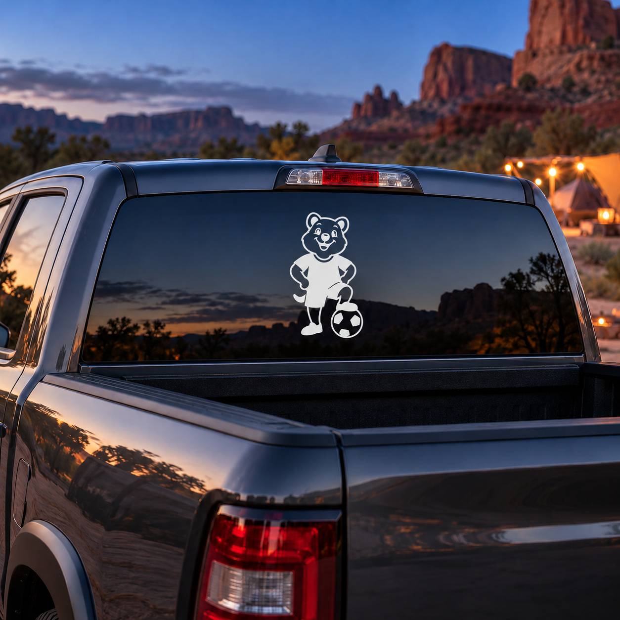 Vinyl car decal of cartoon animal with soccer ball on rear window.