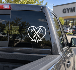 Vinyl heart decal with crossed ski icons and heartbeat line on vehicle window