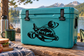 Teal cooler with black space capsule vinyl decal: planet and rocket