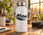 White bottle with black starship vinyl decal over skimming clouds