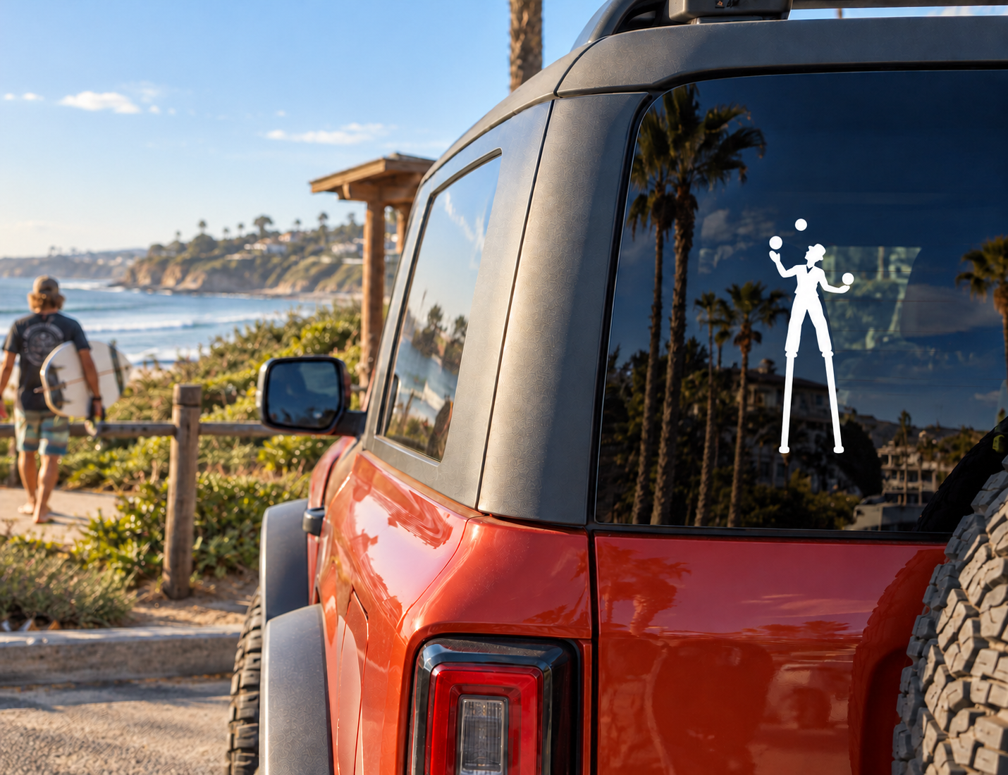 Vinyl decal of a white silhouette juggler on stilts on a car window
