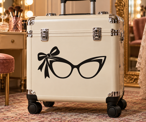 Vinyl sunglasses decal with retro cat-eye glasses and bow, black design on suitcase