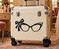 Vinyl sunglasses decal with retro cat-eye glasses and bow, black design on suitcase