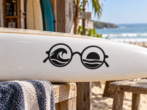 Vinyl sunglasses decal with black frames and ocean wave graphic on a white surface
