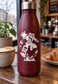 Vinyl decal featuring a leaping superhero character in white, circle-style graphic on bottle