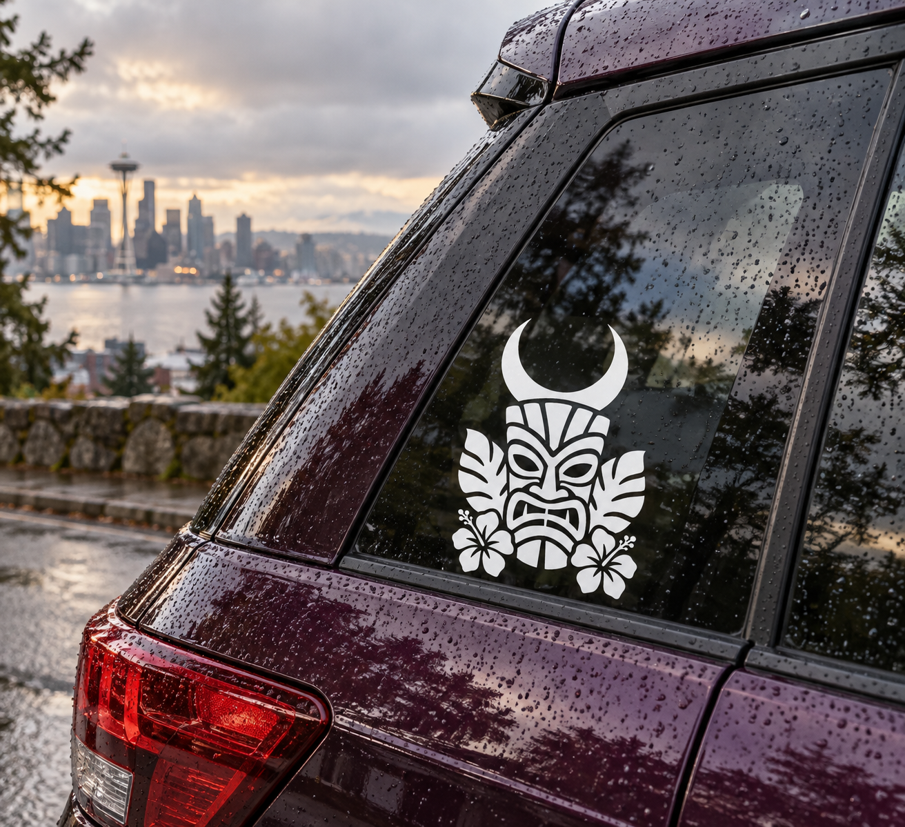Tiki vinyl decal with moon, mask, and floral icons on a car window