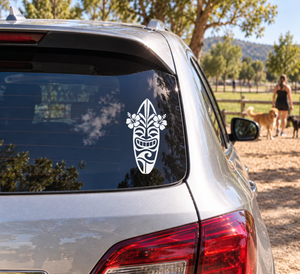 Surf tiki vinyl decal on car rear window, white tribal surfboard face with flowers