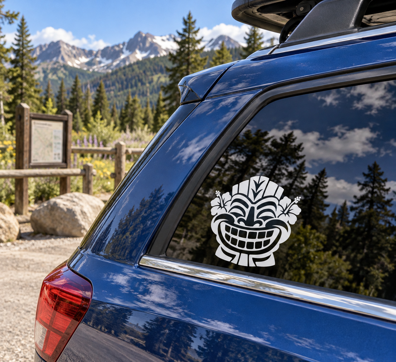 White tiki grin vinyl decal on the rear side window of a blue car
