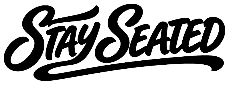 Stay Seated vinyl decal in black cursive lettering, close-up