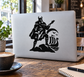 Viking guitarist vinyl decal showing black silhouette with guitar and shield on laptop