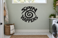 Vinyl wall decal with black SPIN HAPPENS lettering and swirl graphic
