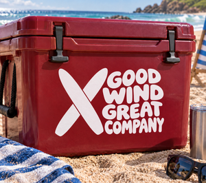 White vinyl decal logo: large X and “GOOD WIND GREAT COMPANY” text on red surface