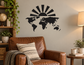 Black vinyl world map wall decal with rising sun rays above the continents