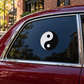 Yin yang sticker with fine circular border on car window, black and white symbol.