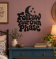 Black vinyl decal with crescent moon, stars, and drippy stylized lettering on wall