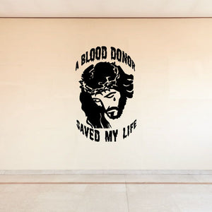 Black circular wall decal with face graphic and text "A BLOOD DONOR SAVED MY LIFE"