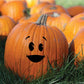 Orange pumpkin decal with smiling baby face, round eyes and curved mouth