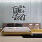 Wall decal with phrase "Be the light of the world" in black lettering