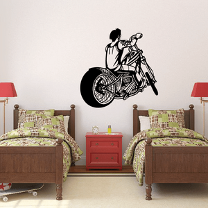 Black vinyl wall decal of a boy riding a motorcycle with helmet and hands on handlebars.