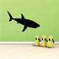 Black shark swimming silhouette wall decal above three yellow figures