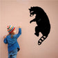 Black raccoon wall decal climbing with paws and curled tail