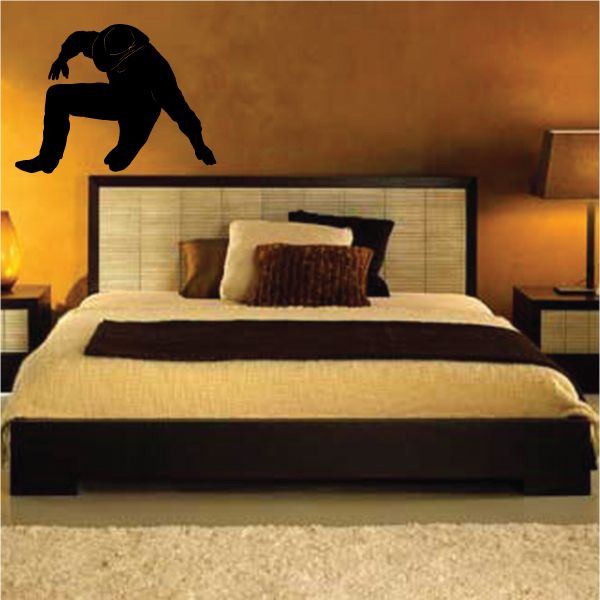 Cowboy wall decal vinyl sticker with black silhouette of a crouching rider and hat