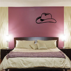 Black cowboy hat wall decal on mauve wall above bed