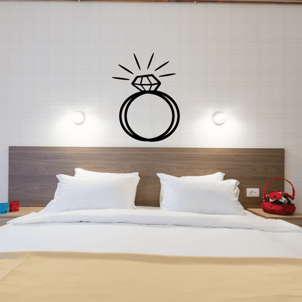 Wall decal of a black diamond ring with small rays above it